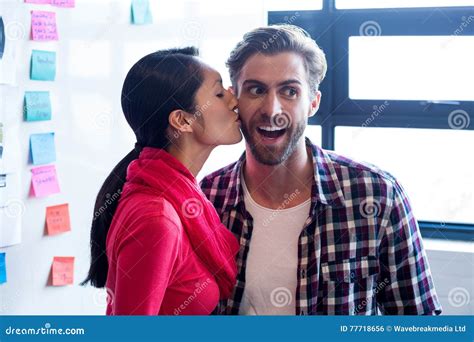 Woman Kissing Male Colleague In Creative Office Stock Photo Image Of