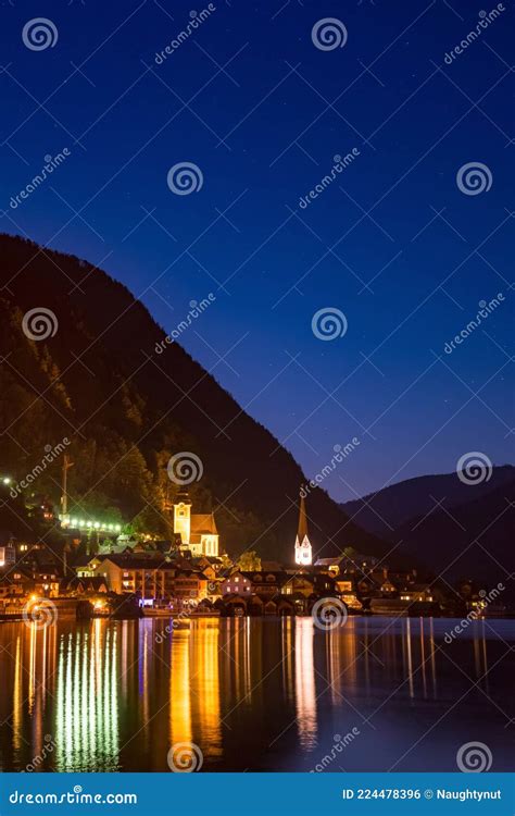 Scenic View Of Famous Hallstatt Lakeside Town Reflecting In