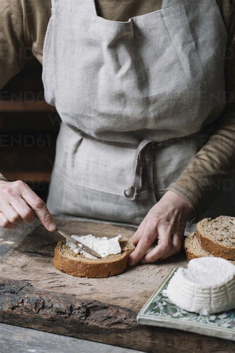 Woman Spreading Ricotta Cheese Onto Slice Of Bread Mid Section Stock Photo