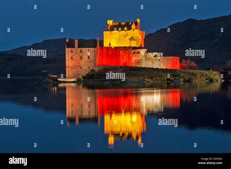 Eilean Donan Castle With Evening Red Lights Reflected On The Sea Loch