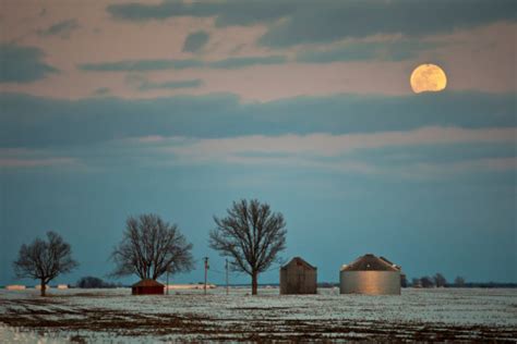 Full Moon Over Snow Covered Fields And Grain Bins Stock Photo