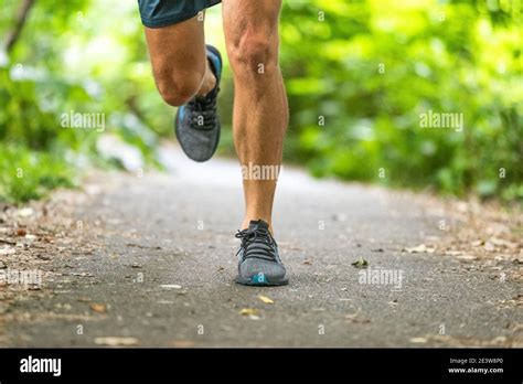 Running Man Runner Athlete Workout Jogging Outdoors On City Park Path With Running Shoes Closeup