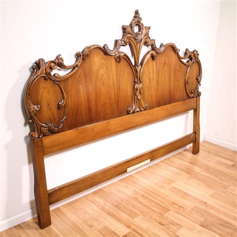 A Wooden Headboard With Ornate Carvings On The Top And Bottom Against