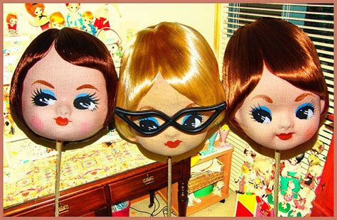 Three Doll Heads Sitting Next To Each Other