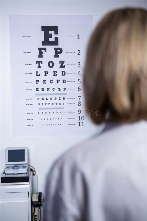 Optometrist Looking At Eye Chart Stock Image Image Of Coat