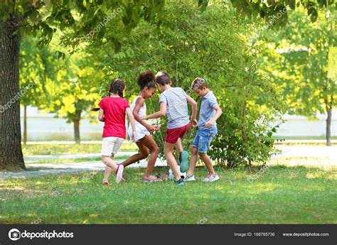 Lindos niños jugando fútbol en el parque Foto de stock belchonock