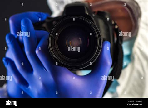 Crime Scene Forensics Investigator With Digital Camera Taking Pictures