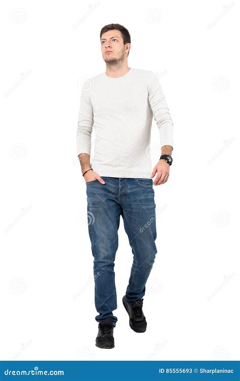 Relaxed Young Man In Casual Wear Walking Towards Camera Looking Up