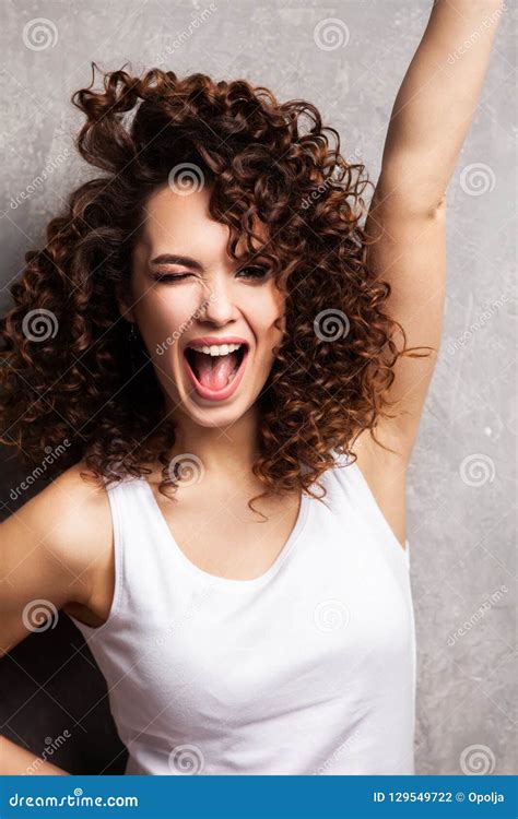 Portrait Of Beautiful Cheerful Girl With Flying Curly Hair Smiling Laughing Looking At Camera