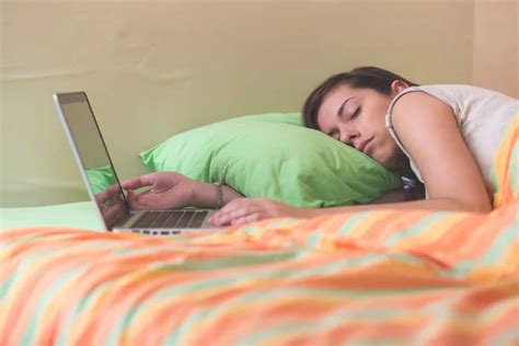 Young Woman Falling Asleep While Using Notebook On Bed Stock Image Everypixel