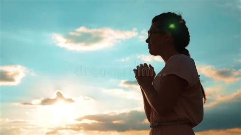 Girl Folded Her Hands In Prayer Silhouette At Sunset Woman Praying On