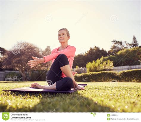 Active Senior Woman Doing A Yoga Twist Outdoors Stock Photo Image