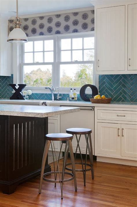 Turquoise kitchen features a beadboard ceiling lined with a pair of sloane single pendants illuminating center island lined with turquoise counter stools situated across from white shaker cabinets paired with white quartz countertops and a white and turquoise blue mosaic glass tiled backsplash which frame windows dressed in light gray sheer cafe curtains. Kitchen with Turquoise Herringbone Backsplash ...