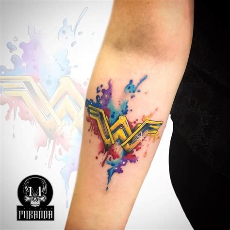 A Woman S Arm With A Watercolor Splattered Tattoo Design On It