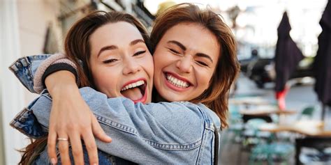 Close Up Photo Of Laughing Woman Friends Hugging Each Other On City