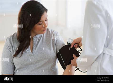 Doctor Checking Womans Blood Pressure Stock Photo Alamy