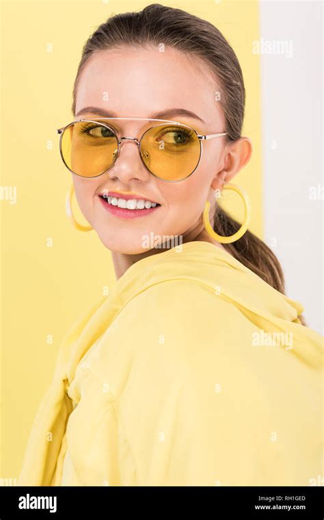 Beautiful Fashionable Girl In Sunglasses Smiling And Posing With Limelight On Background Stock