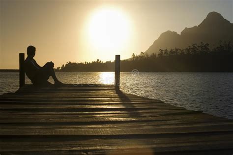 Man Sitting On Dock By Lake Royalty Free Stock Images Image 33893039