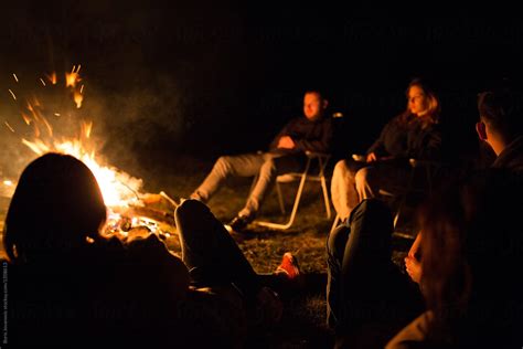 Friends Enjoying Their Time Around Campfire By Stocksy Contributor