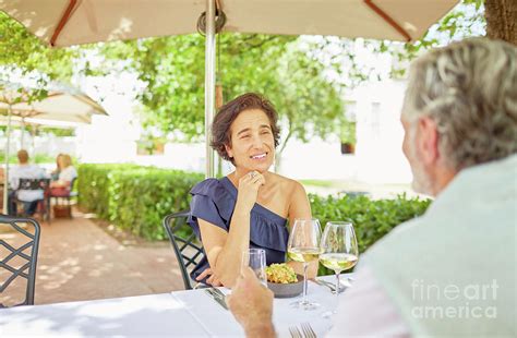 Mature Couple Dining At Resort Patio Table Photograph By Caia Image