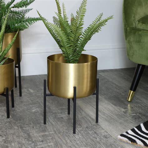 Brighten any room with a hanging metal planter beside the window for modern decor that takes up neither cabinet nor floor space. Round Gold Plant Stand - Medium