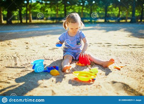 Adorable Little Girl Having Fun On Playground In Sandpit Stock Image