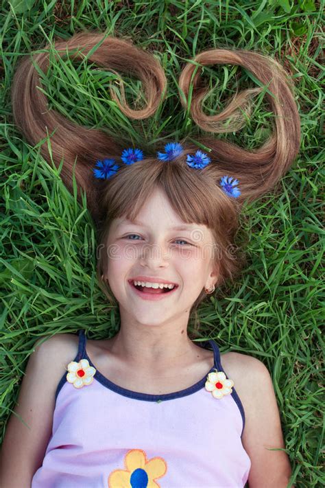 funny girl lying on the grass and pulling her hair with cornflowers stock image image of