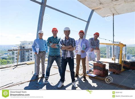 Builders Team Leader With Group Of Apprentices At Construction Site