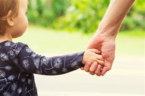 Toddler Girl Holding Hands With Her Father Stock Photo Download Image