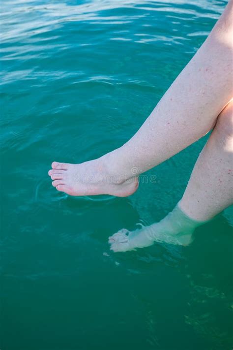 Unrecognizable Caucasian Woman Dipping Her Bare Feet In Clean And Clear