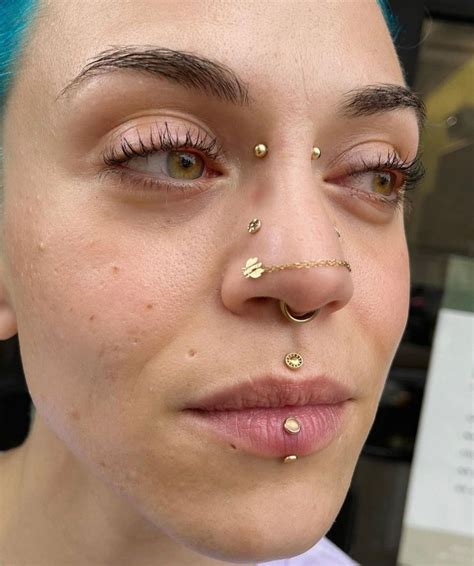 A Woman With Blue Hair And Piercings On Her Nose