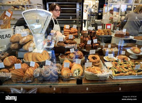 Baked Goods For Sale Inside Tatte Bakery And Cafe With A Female Store