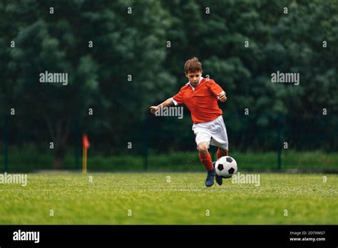 Soccer Shooting Boy Kicking Soccer Ball On Grass Field Young Football