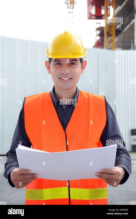 Asian Engineer Or Foreman Wearing Safety Vest And Hard Hat Stock Photo