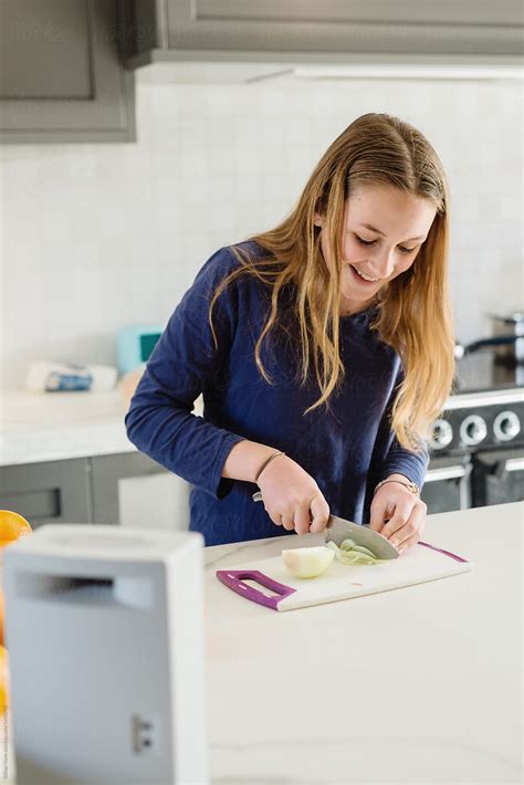 Teen Listening To Music As She Cooks In The Kitchen By Stocksy