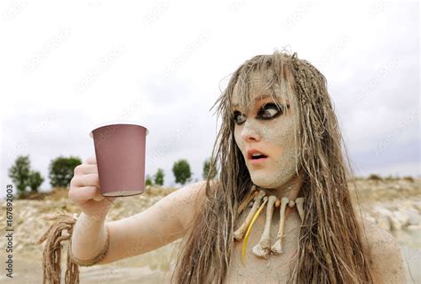 A Girl Gets Herself Made Up As A Prehistoric Cave Woman And Is Covered With Mud She Poses For