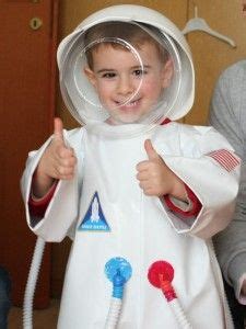 La zona delle coppe e le maniche dell'abito sono rosse mentre la parte inferiore è nera con inserti rossi e decorata da bottoni. Astronauta. Costume da astronauta in plastica con casco ...