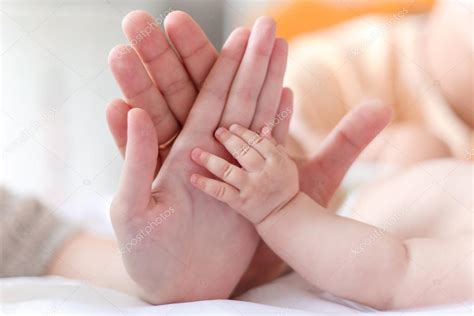 Father And Mother Hold In Their Hands A Little Newborn Babys Hand