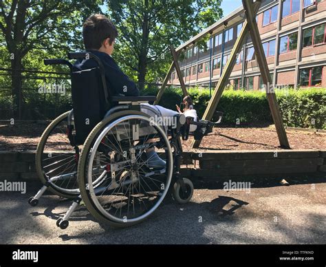 Boy With Broken Leg Sitting In The Wheelchair And Looking To Girl On