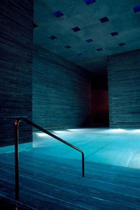 An Indoor Swimming Pool With Steps Leading Up To It And Lights Shining