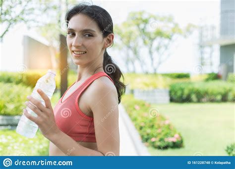 Beautiful Sport Woman Holding Bottle Of Drinking Water After Exercise