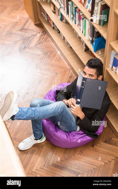 Handsome Man Reading Book In Library Stock Photo Alamy