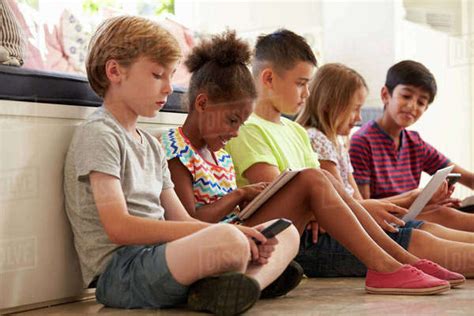 Group Of Children Sit On Floor And Use Technology Stock Photo Dissolve