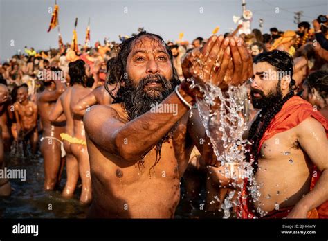 A Hindu Worshipper Praying And Bathing In The Sacred Ganges River With Thousands Of Other