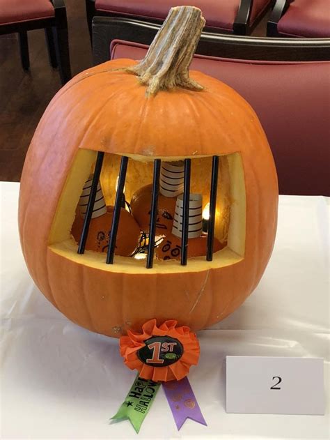 A Pumpkin With A Birdcage In It On Top Of A Table Next To A Ribbon