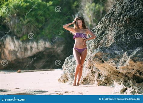 Slender Tanned Girl In Swimsuit Posing On Beach With Sand And Large