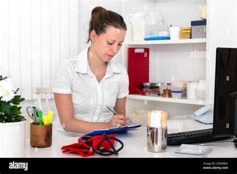 Female Doctor Nurse Or Secretary Is Doing Some Paperwork In The