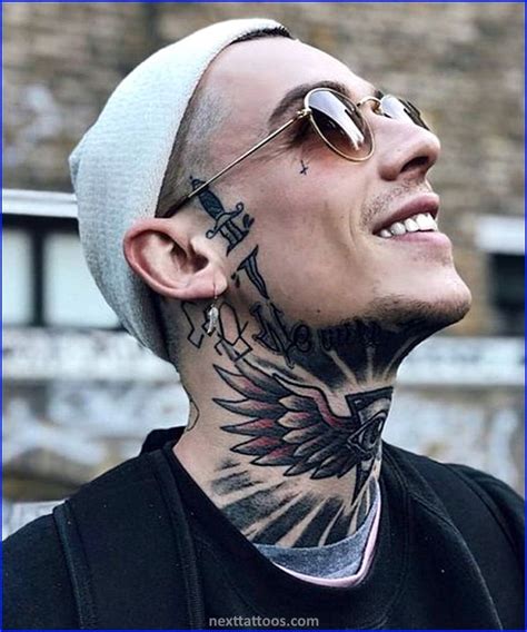 A Man With Tattoos On His Face And Neck Looking Up At The Sky While