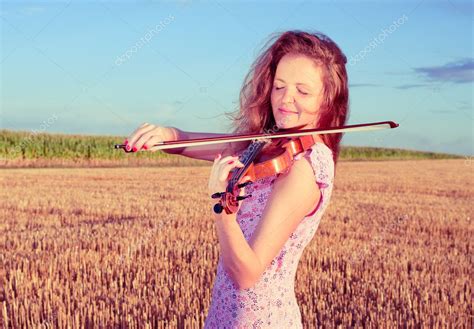 Redhead Woman Playing Violin Outdoors On The Field Split Toning Stock