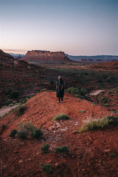 Young Man Standing On Edge Of Cliff In Valley Of The Gods Desert